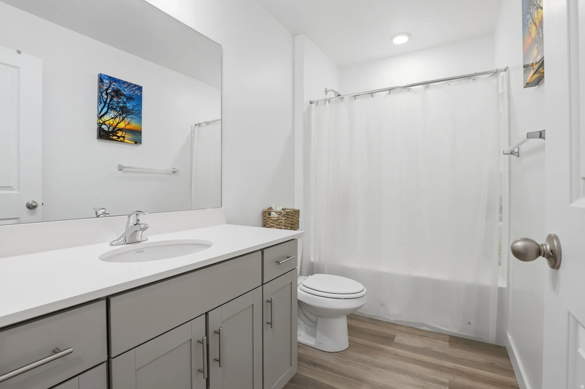 Bathroom featuring a single vanity with gray cabinetry, a white countertop, an undermount sink, and chrome fixtures