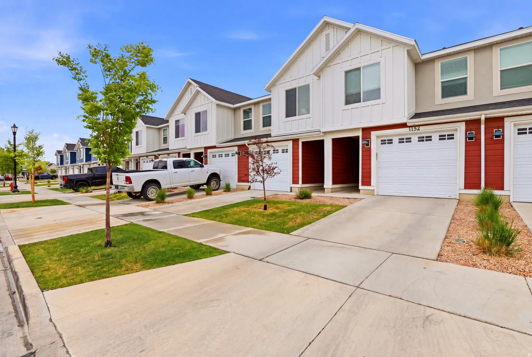 Contemporary townhome exterior featuring vertical white siding and red horizontal siding accents