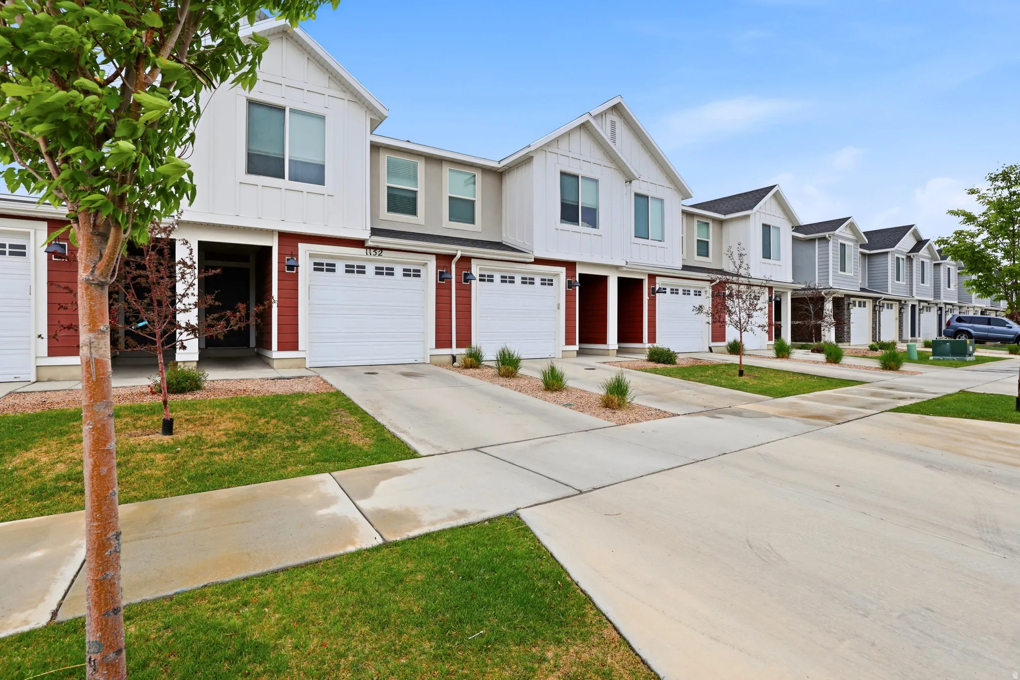 Modern townhome exterior featuring red siding and white trim