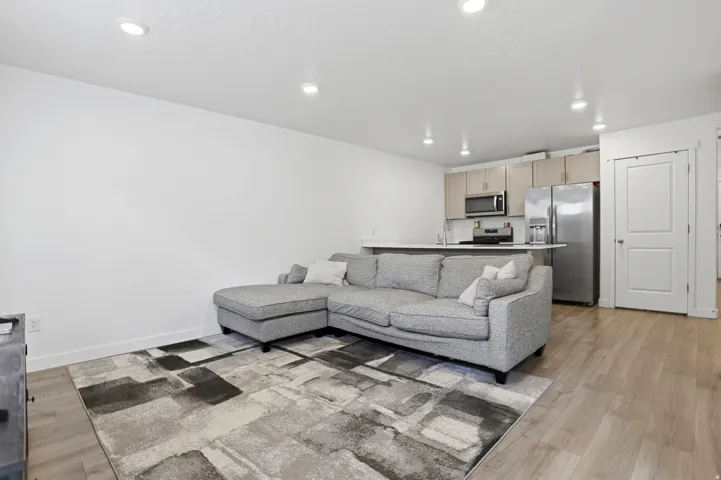 Open-concept living space featuring wood-finish flooring, recessed lighting, and white walls