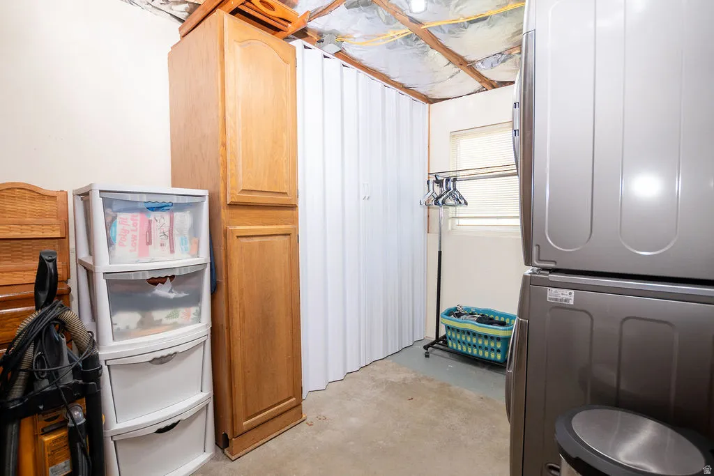 Utility area featuring built-in wood-finish cabinetry, a white accordion partition, and a single window