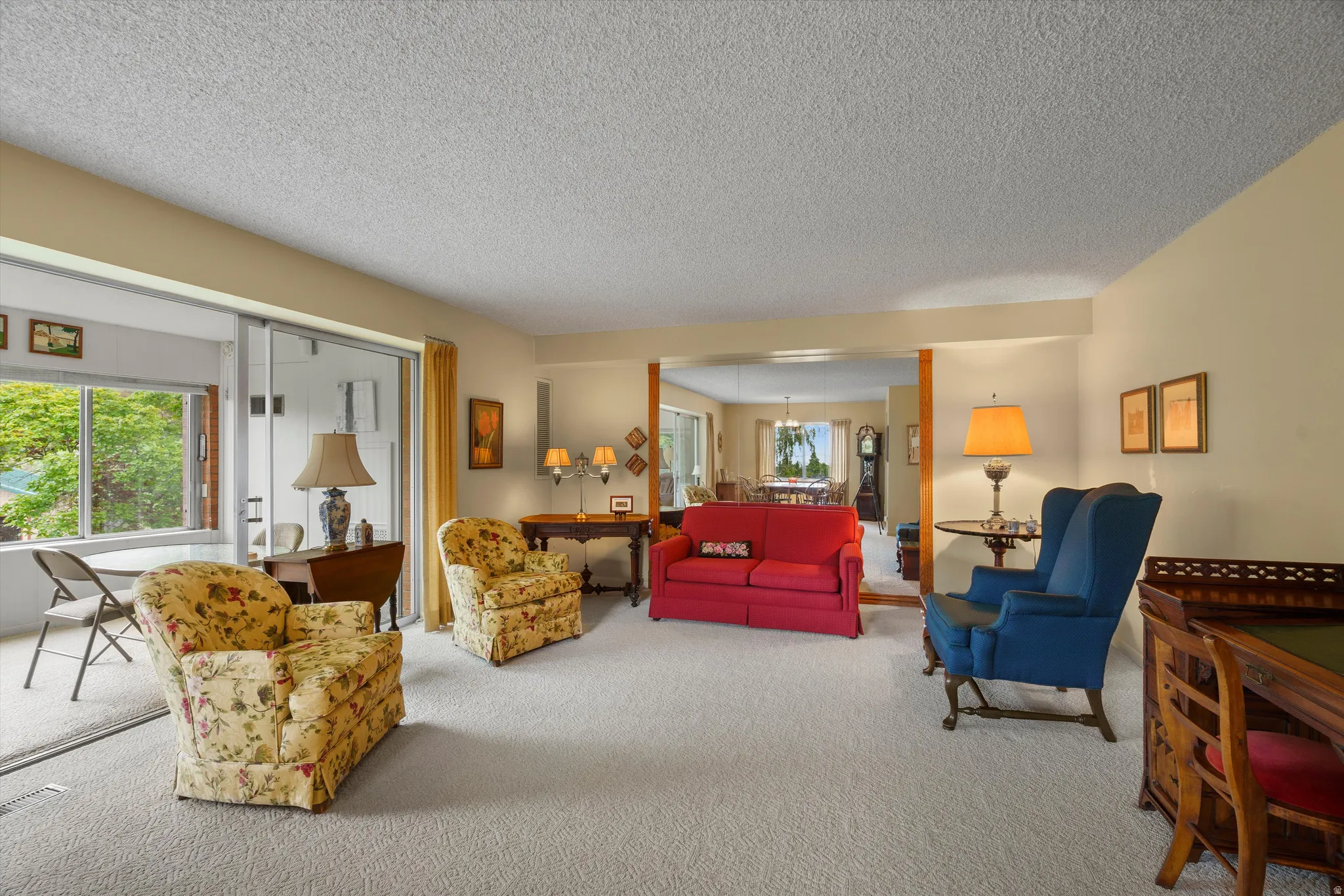 Carpeted living area with light-colored walls and a textured ceiling