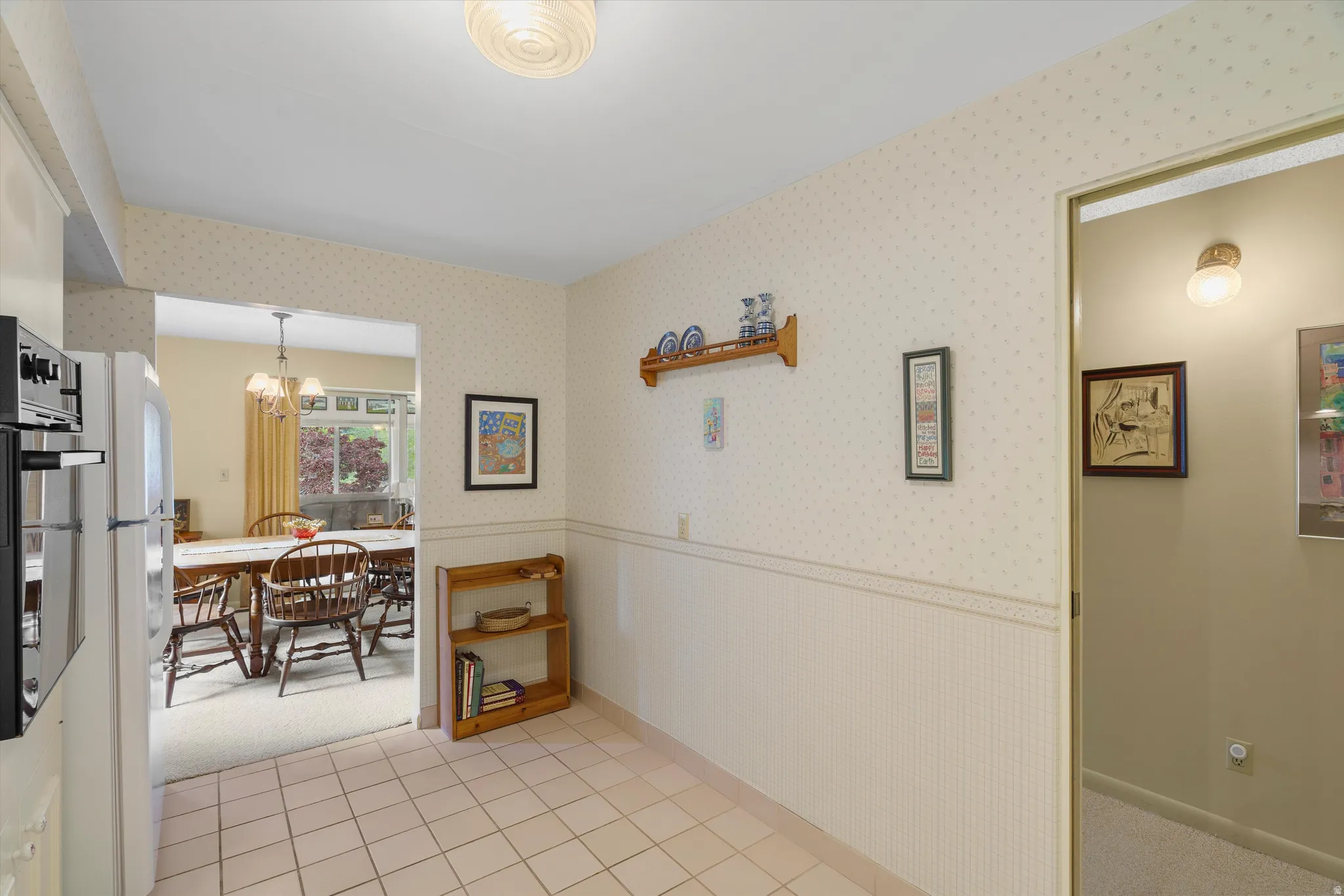 Tiled flooring in a neutral tone and a built-in oven, refrigerator, and microwave in a white finish