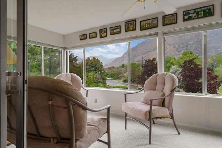 Sunroom featuring floor-to-ceiling windows, mountain scenery, and white carpeting