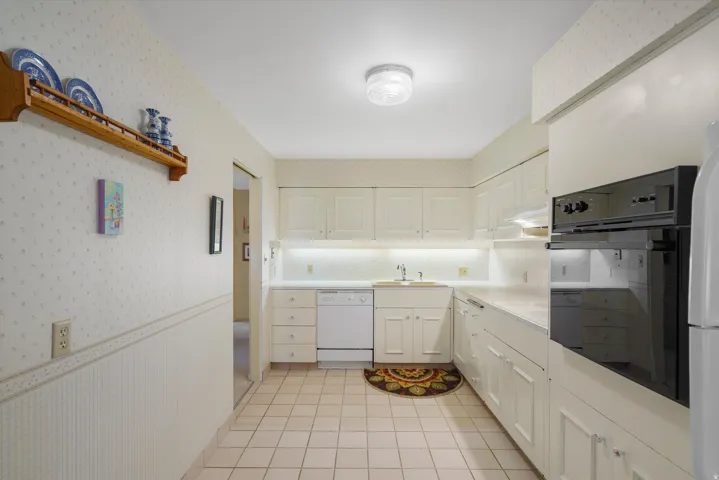 Kitchen featuring white cabinetry, light countertops, and ceramic tile flooring