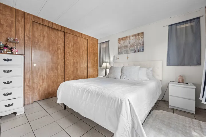 Bedroom featuring wood-panel accent wall with double sliding closet doors