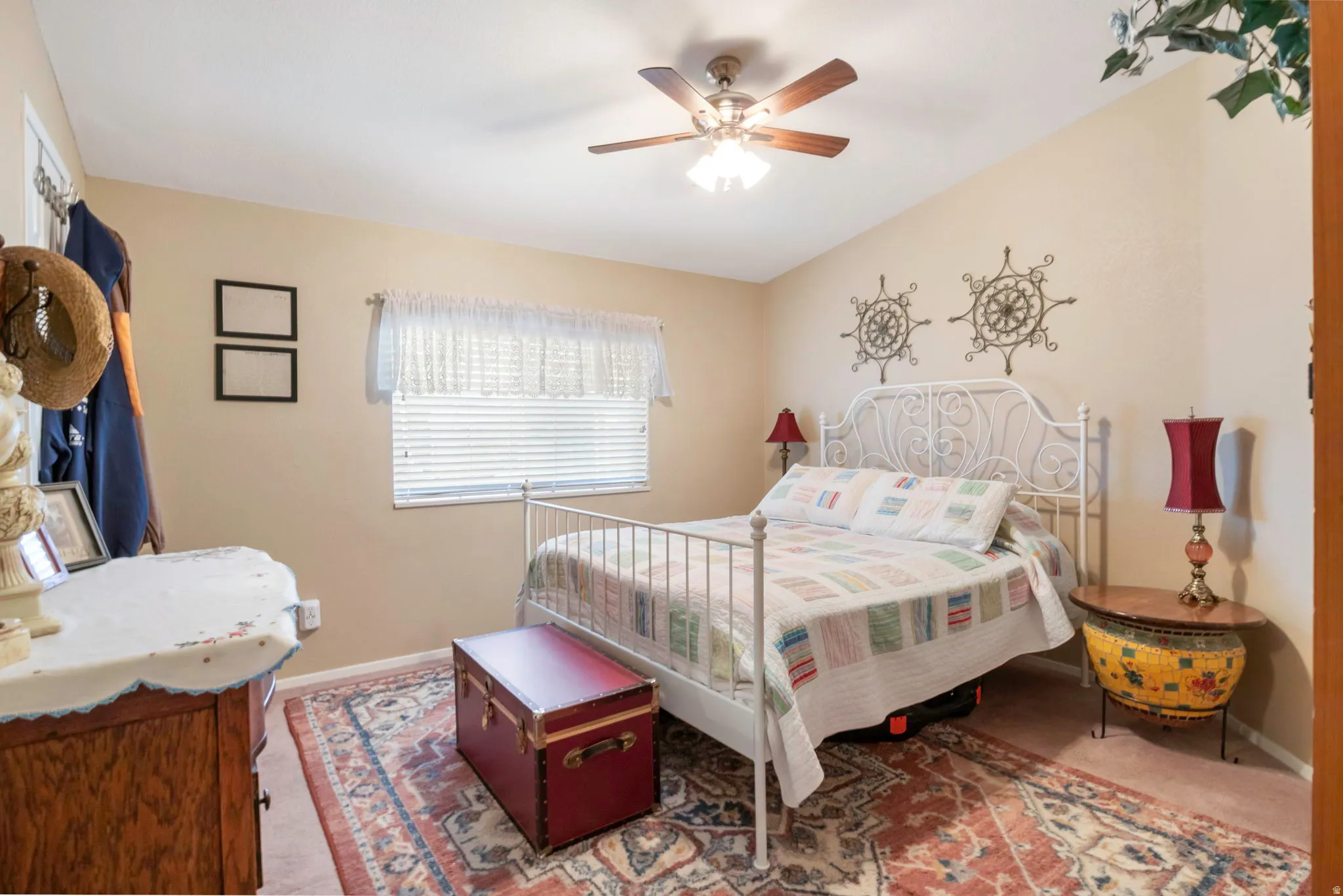 Bedroom featuring a vaulted ceiling, ceiling fan with integrated lighting, window with blinds, and neutral wall tones