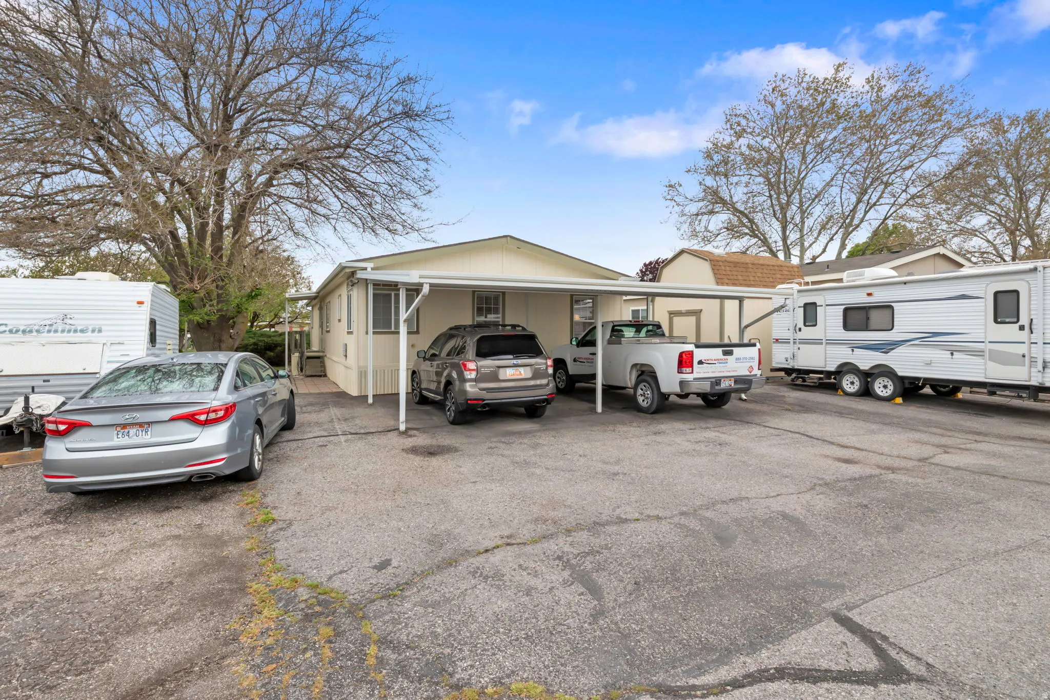 Single-story residence featuring a carport and additional paved parking