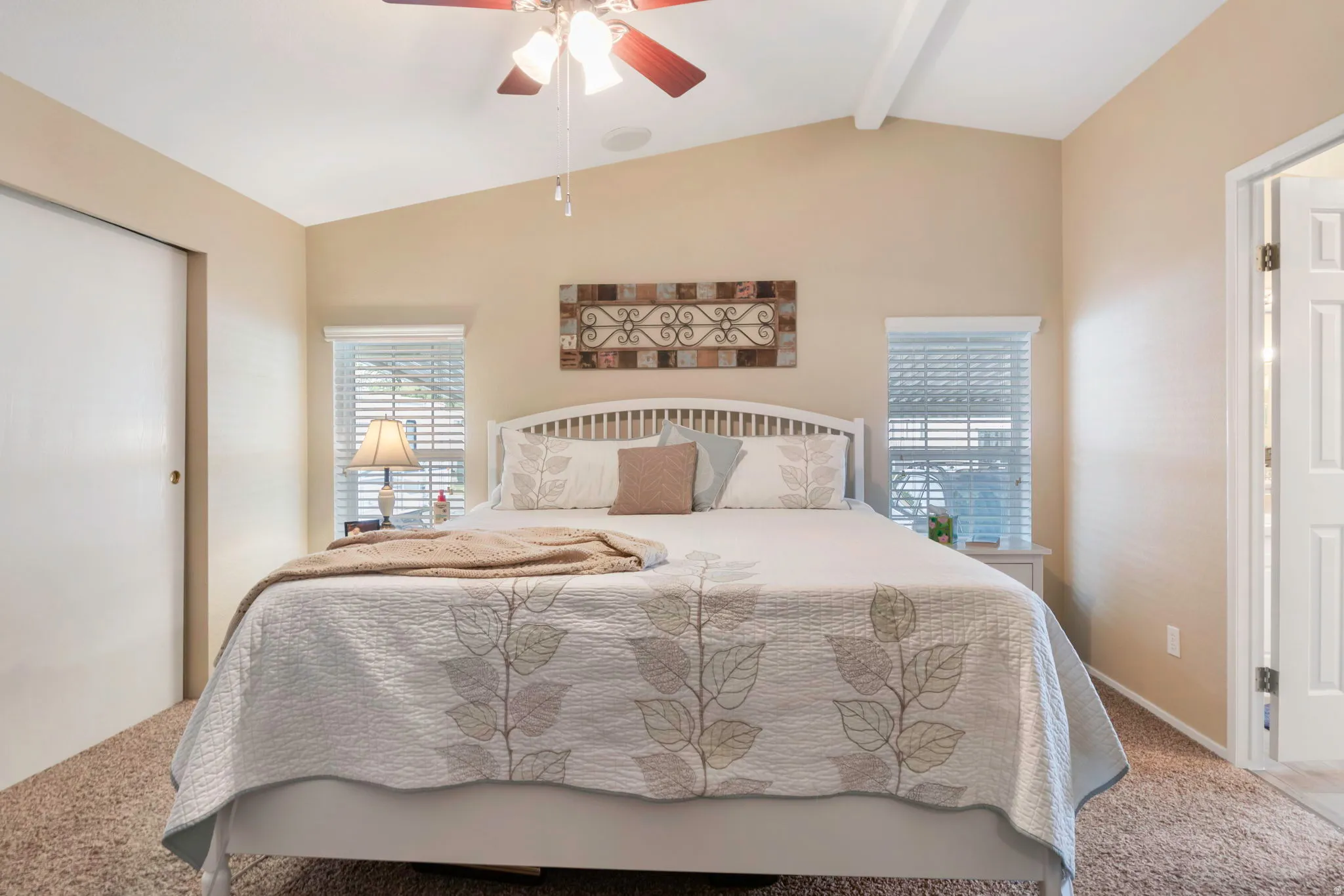 Vaulted ceiling with an exposed beam and ceiling fan