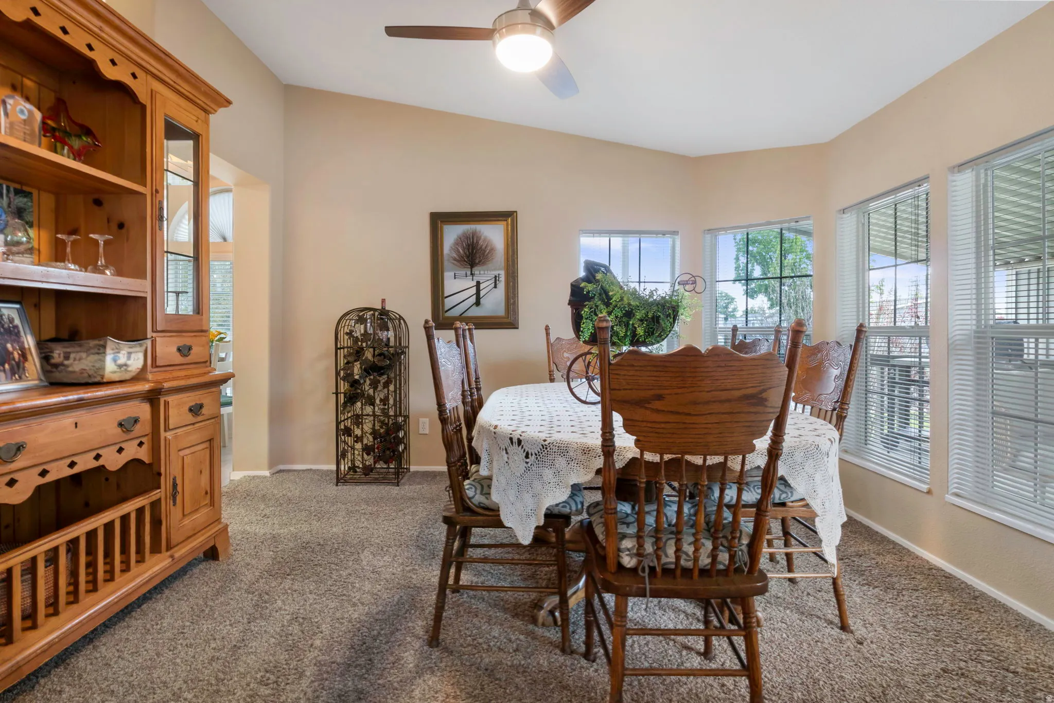 Dining area featuring multiple windows, sloped ceiling, and a ceiling fan with integrated lighting