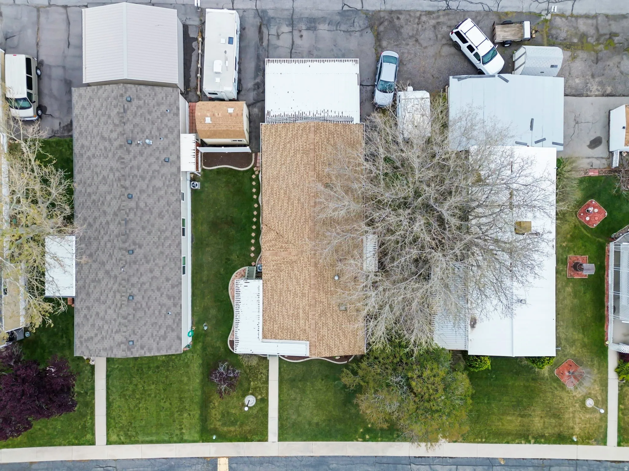 Aerial perspective showcasing three residential properties with varied roofing materials
