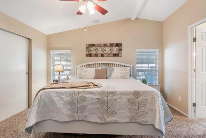 Vaulted ceiling with an exposed beam and ceiling fan