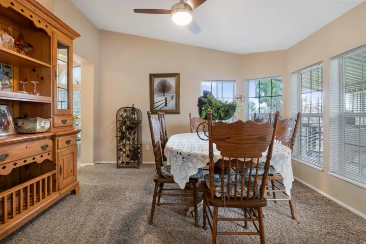 Dining area featuring multiple windows, sloped ceiling, and a ceiling fan with integrated lighting