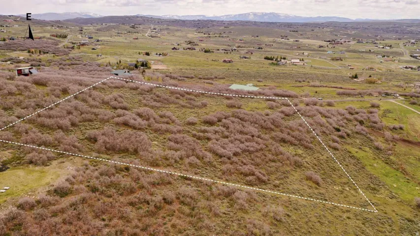 Expansive undeveloped land parcel featuring natural shrubbery and varied terrain