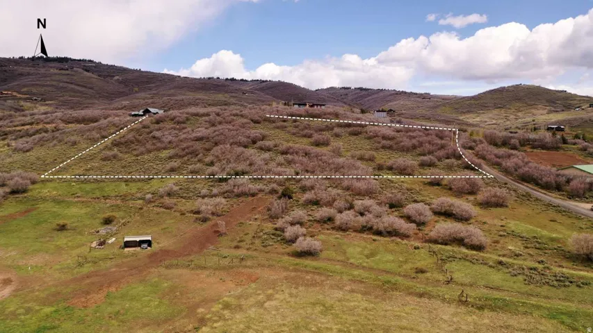 Expansive undeveloped land parcel featuring varied topography, natural shrubbery, and a defined boundary