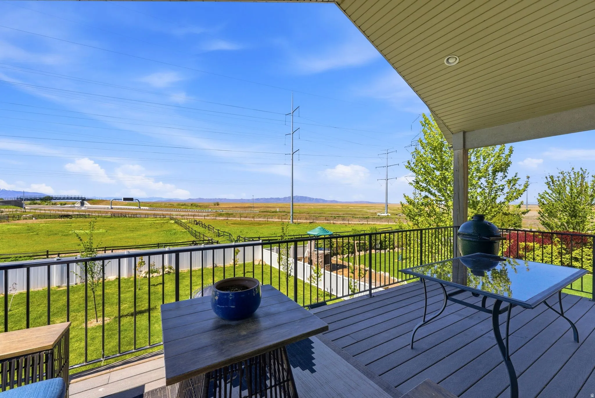 Wooden terrace featuring a lawn, grilling area, a mountain view, and a rural view