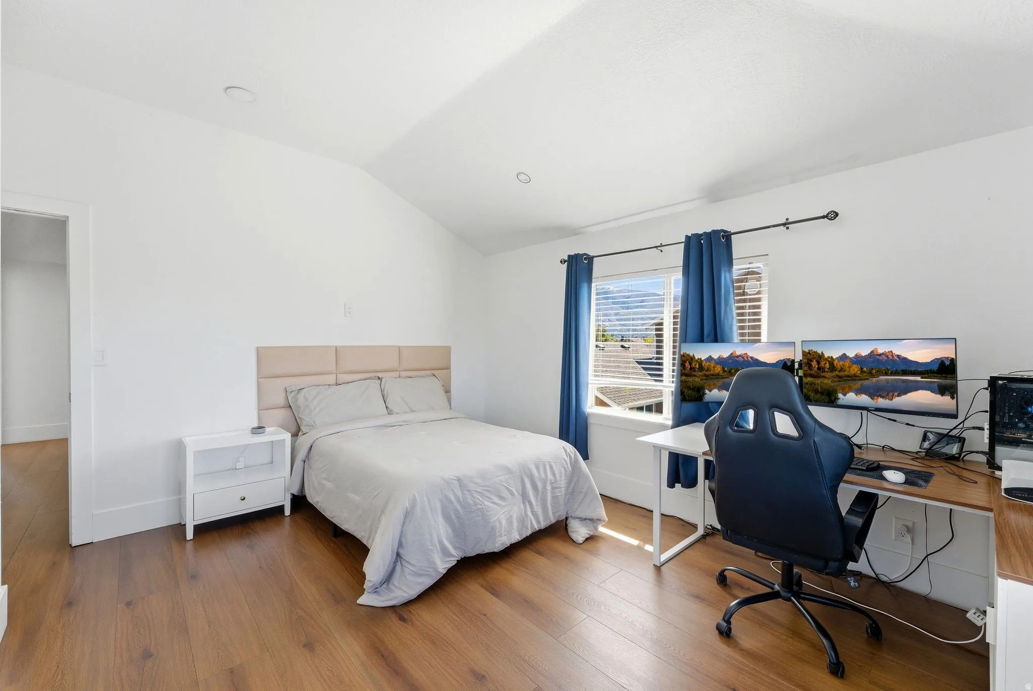 Bedroom featuring vaulted ceiling, a desk, and hardwood / wood-style floors