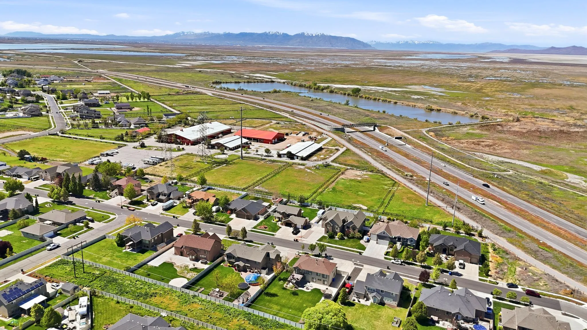 Aerial view of property and surrounding area featuring a water and mountain view and nearby suburban area