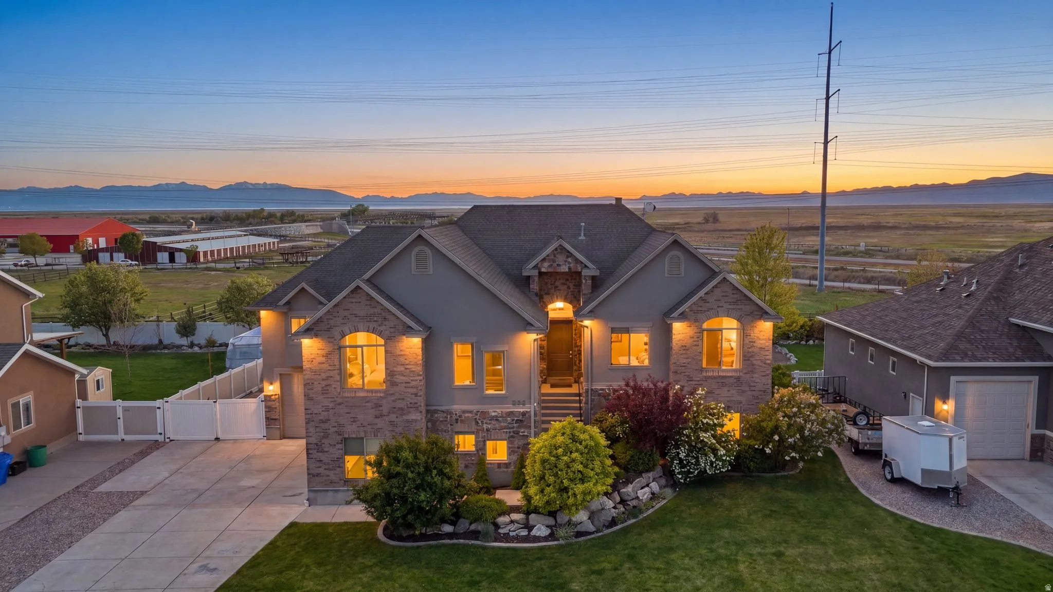 View of front of home with a gate, a mountain view, driveway, and stone siding