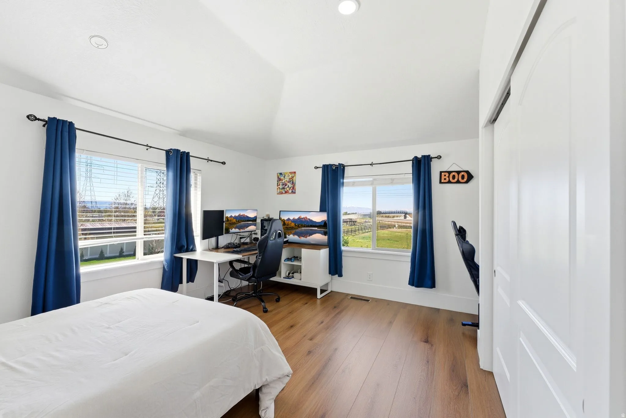 Bedroom with a desk, vaulted ceiling, and light wood finished floors