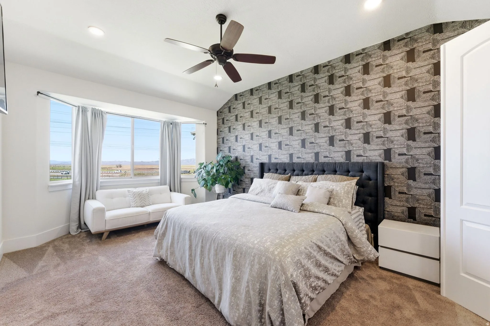 Carpeted bedroom with an accent wall, ceiling fan, lofted ceiling, wallpapered walls, and recessed lighting