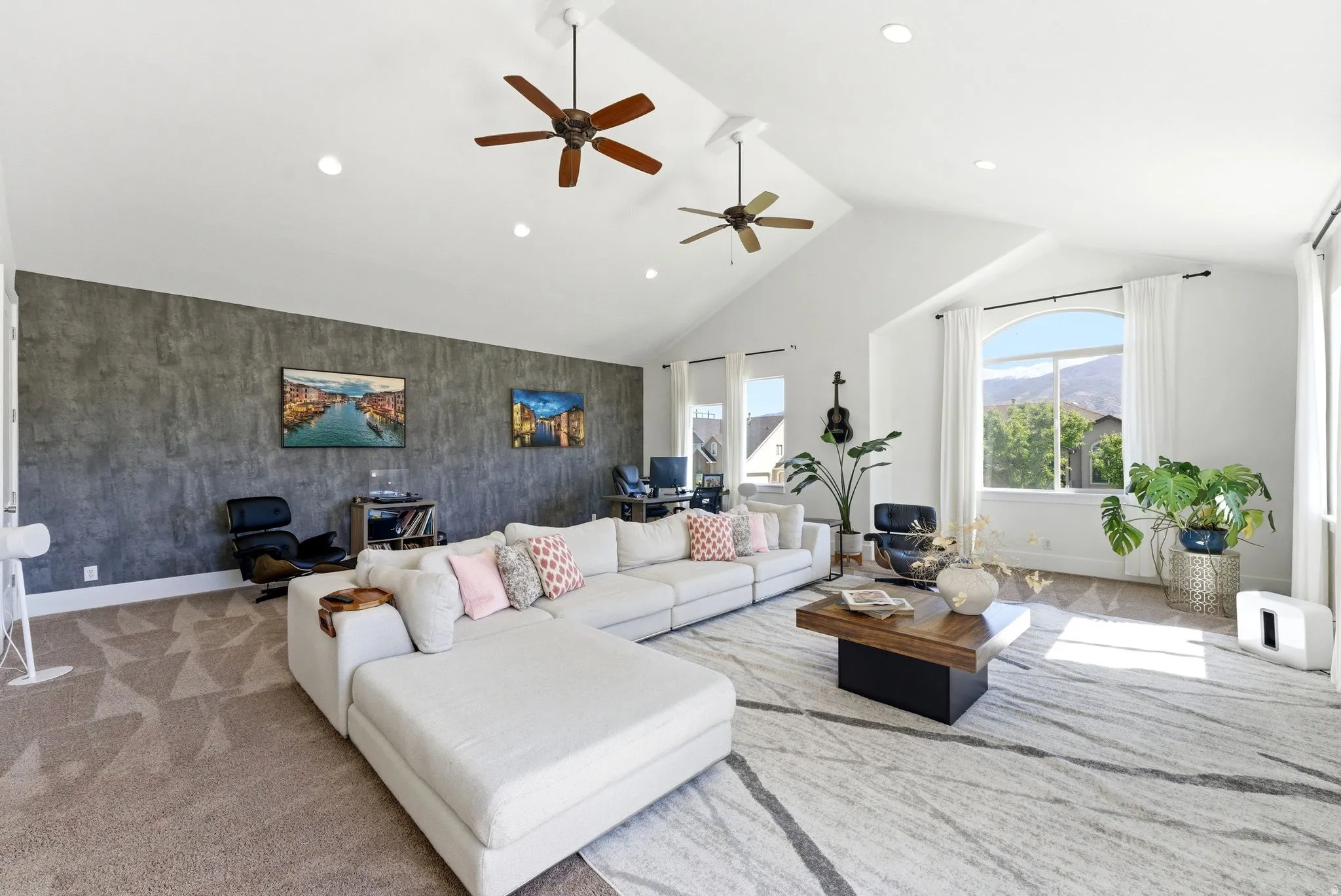 Living room featuring a high ceiling, recessed lighting, ceiling fan, carpet flooring, and an accent wall
