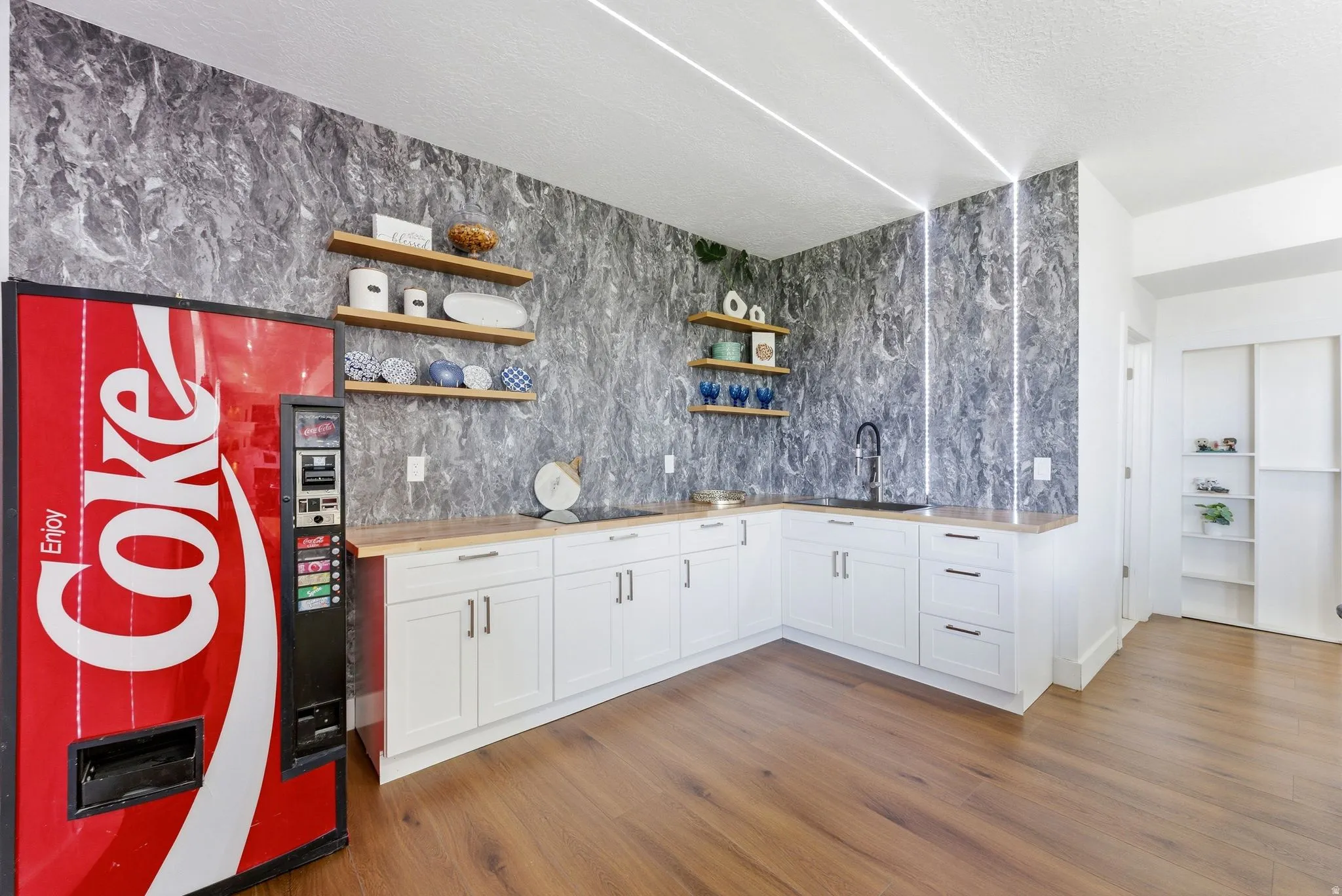 Bar area featuring open shelves, white cabinetry, wooden counters, dark wood-type flooring, and a textured ceiling