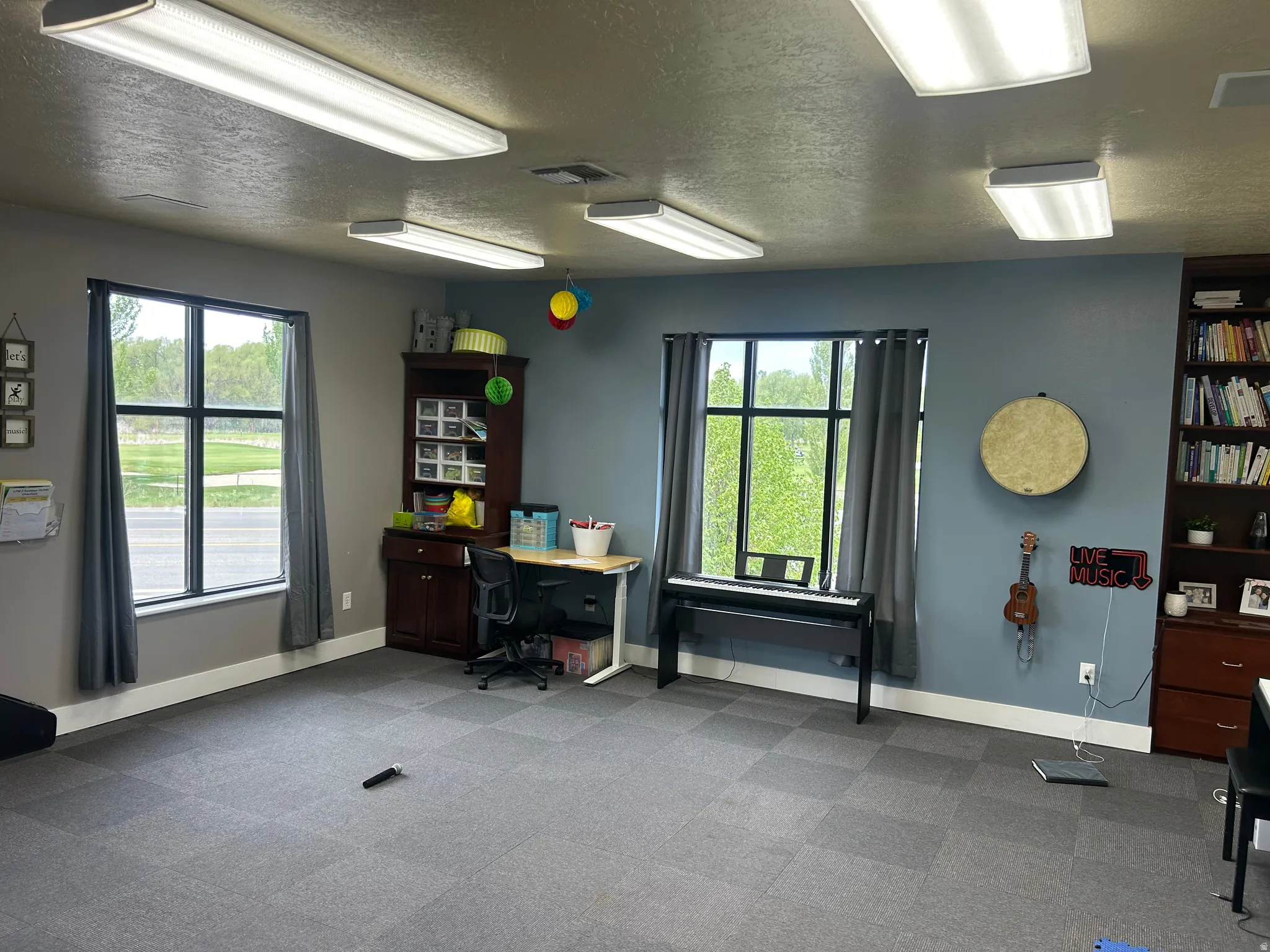 Spacious room featuring dual multi-pane windows with gray drapery, recessed lighting, and modular carpet flooring