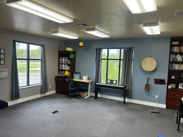 Spacious room featuring dual multi-pane windows with gray drapery, recessed lighting, and modular carpet flooring