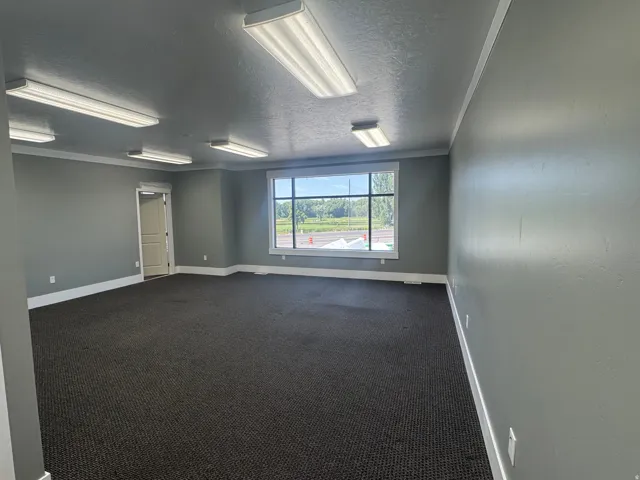 Spacious room featuring broadloom carpeting and grey painted walls