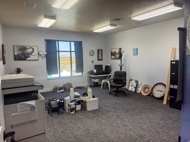 Spacious interior room featuring grey patterned carpet and white walls
