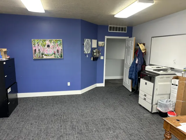 Spacious room featuring broadloom carpeting, a multi-tone wall treatment, and white baseboards