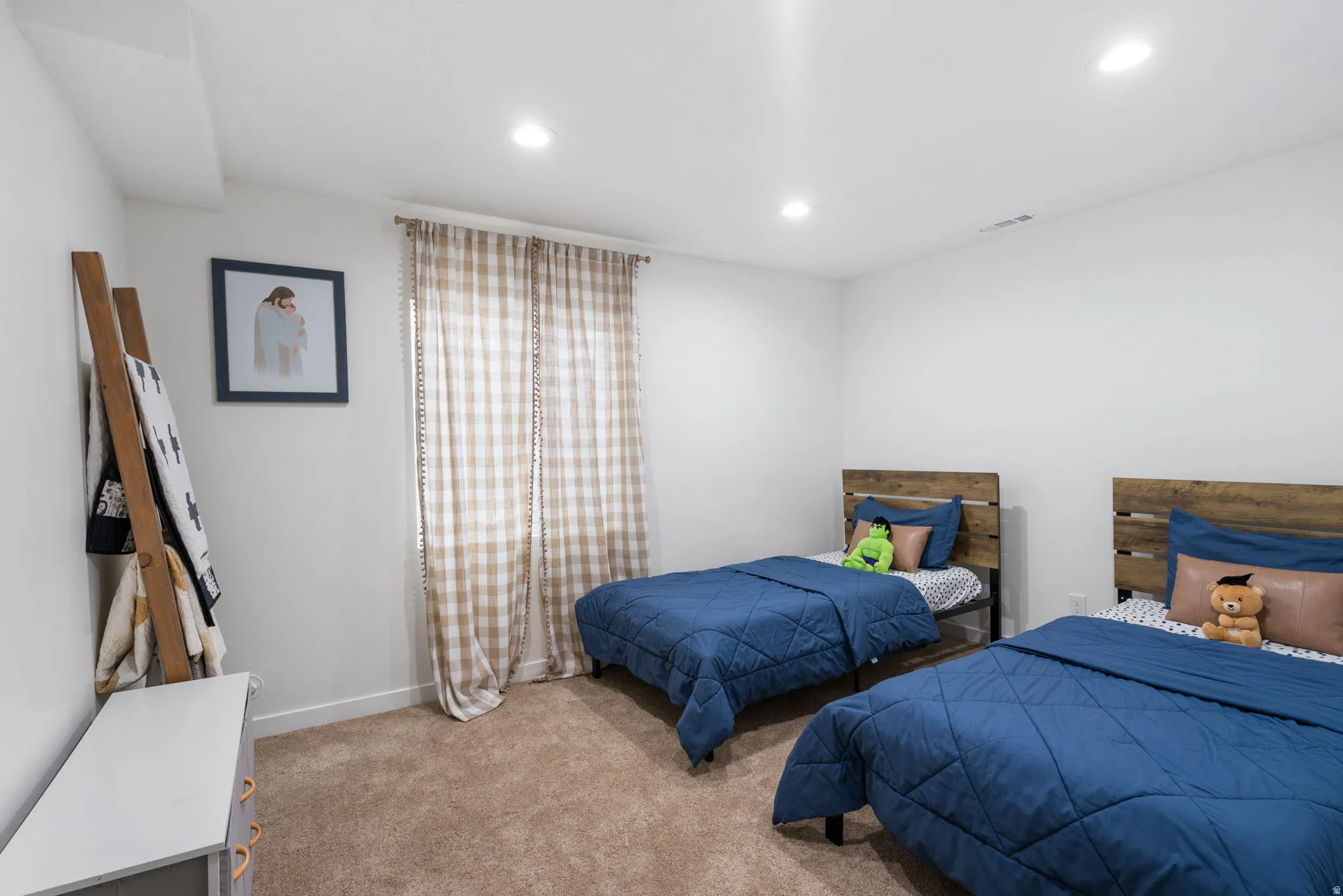 Carpeted interior room featuring recessed lighting, a window with plaid curtains, and white walls