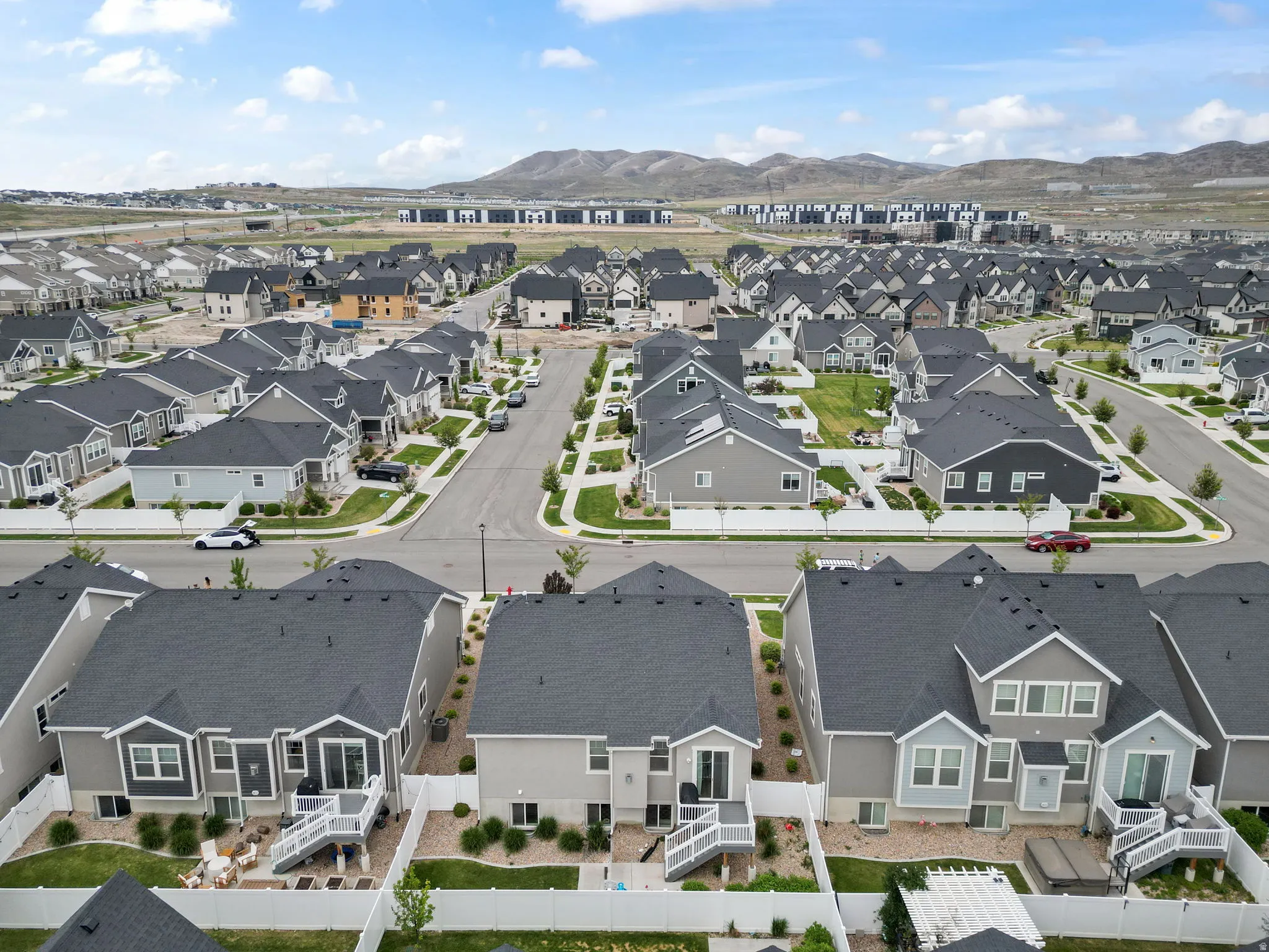 Aerial perspective showcasing a residential neighborhood with uniform rooflines and a mountainous backdrop