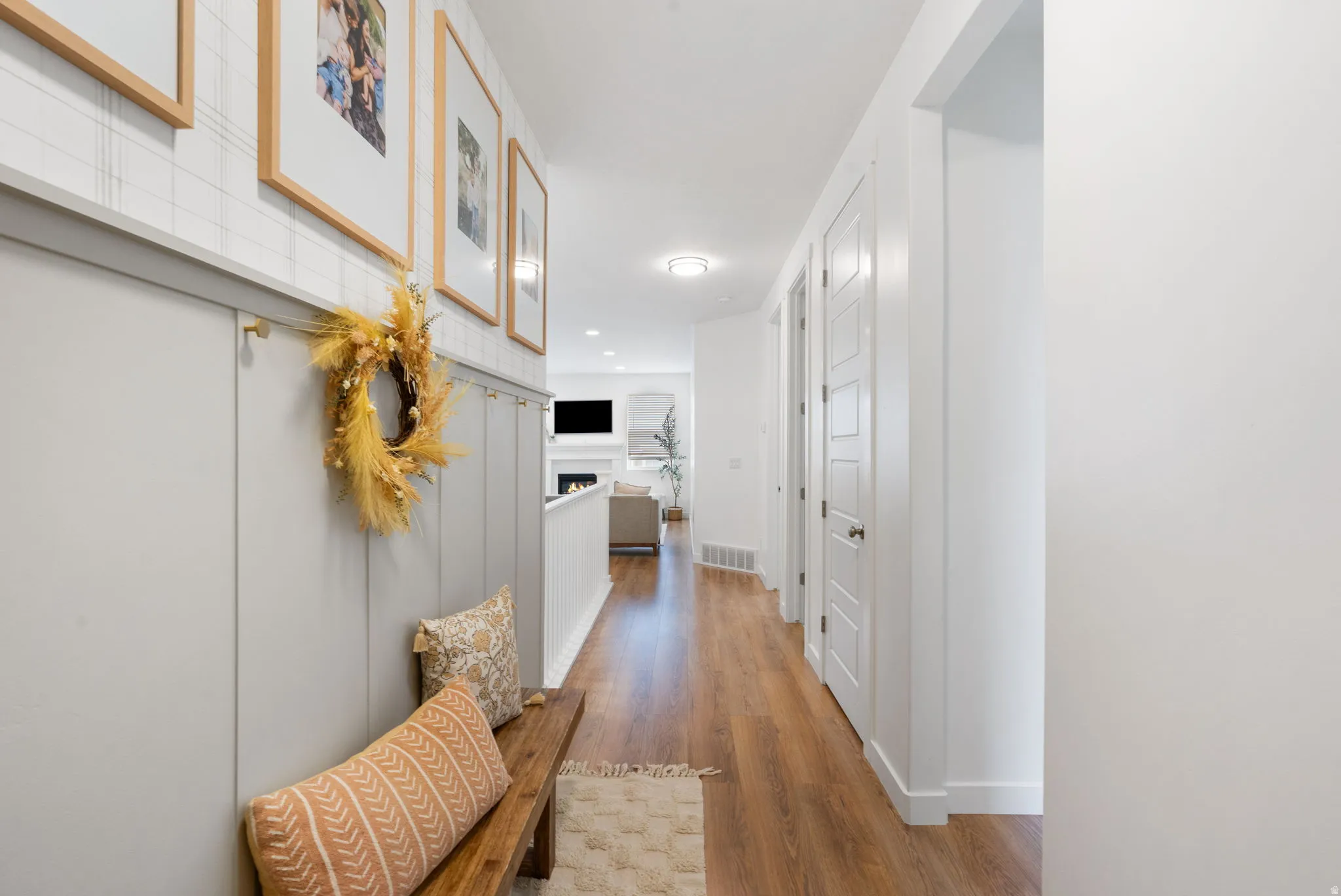 Hallway featuring wood-finish flooring, white paneled doors, and recessed lighting