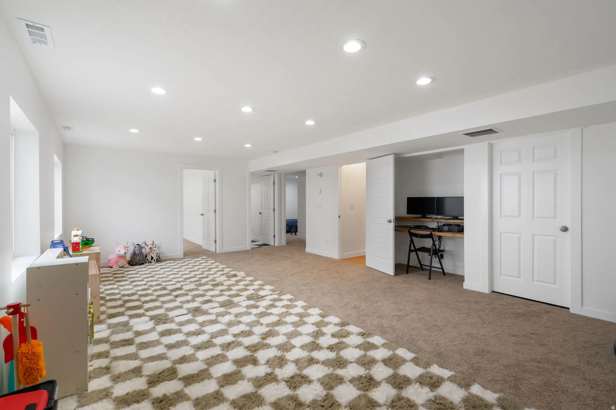 Spacious room with recessed lighting and neutral wall tones