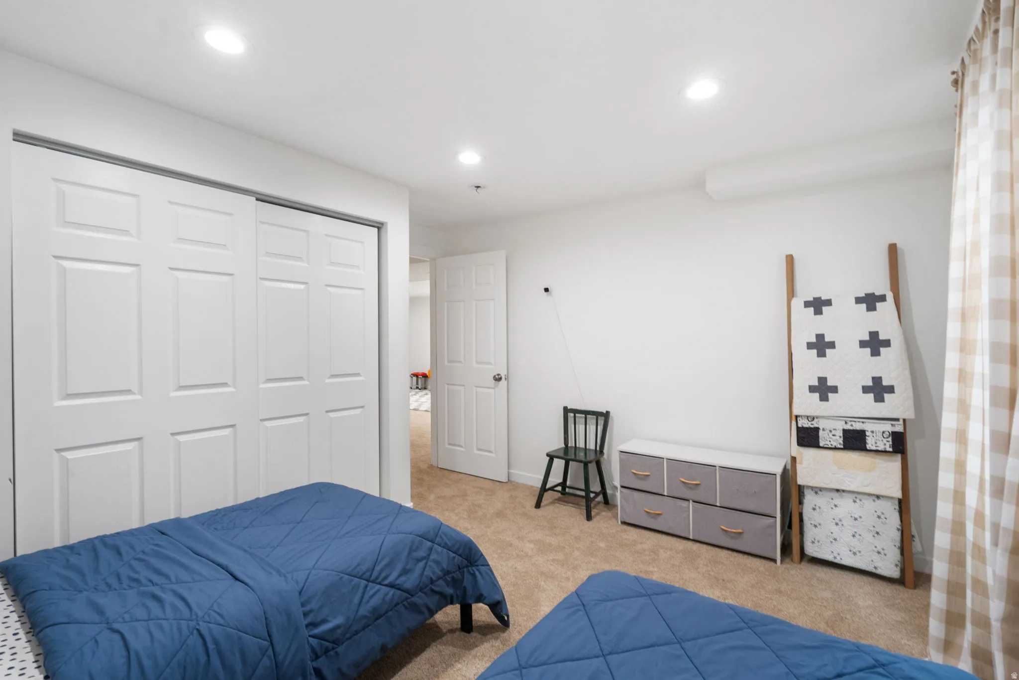Carpeted room featuring recessed lighting, white paneled bifold closet doors, and white walls