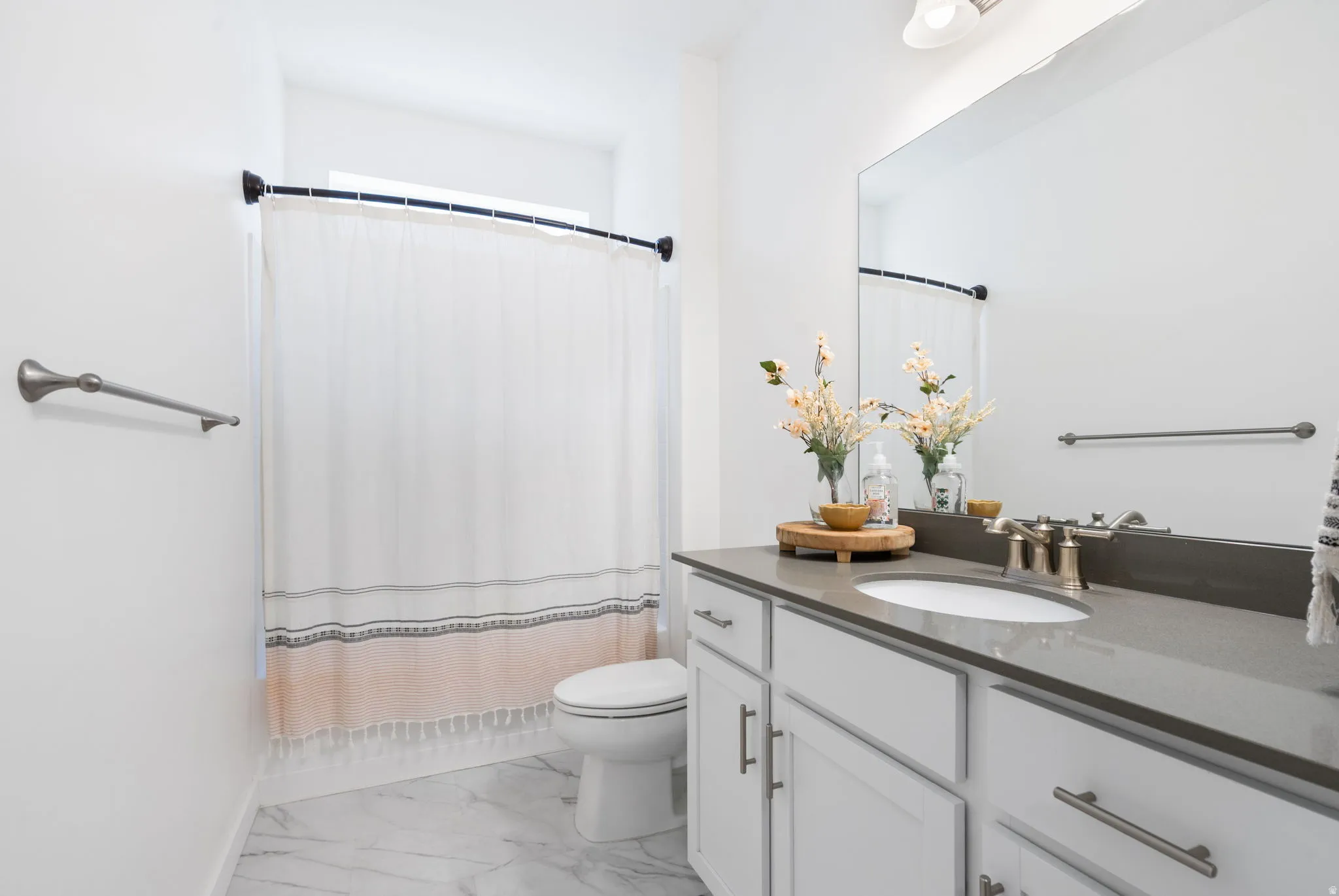 Bathroom featuring a vanity with white cabinetry, a light gray countertop, and an oval undermount sink