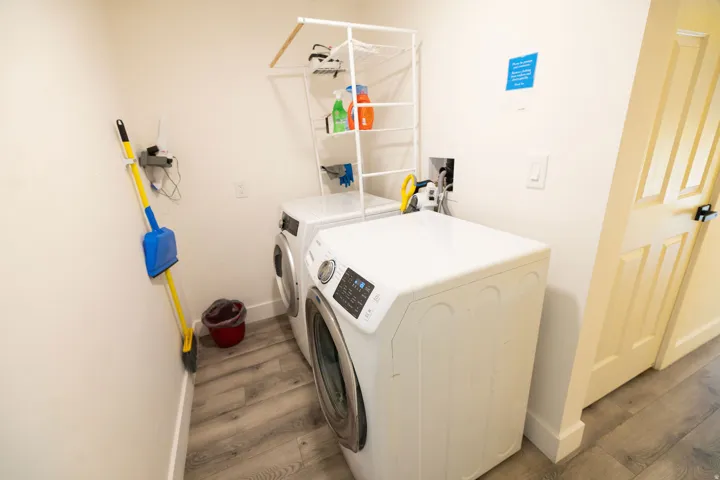 Laundry room with washing machine and clothes dryer and wood finished floors