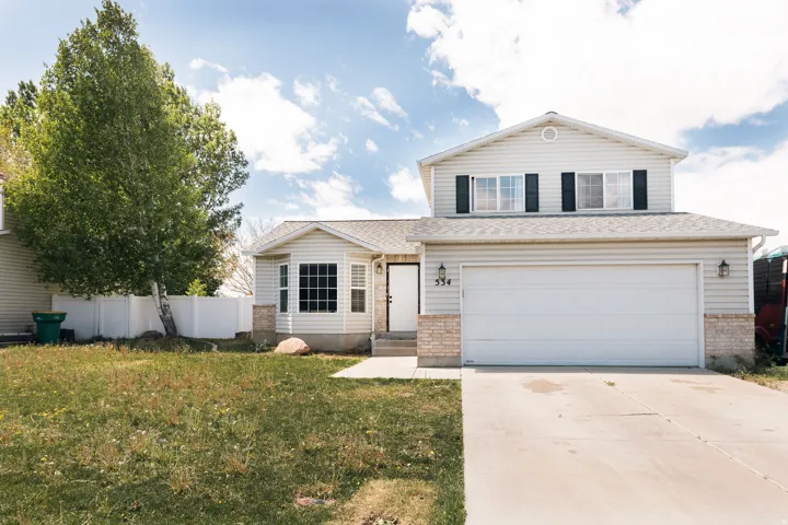 Traditional home with driveway, brick siding, and a garage