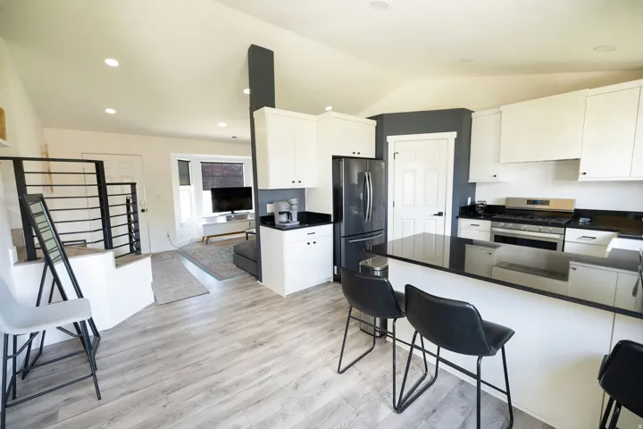 Kitchen featuring stainless steel appliances, white cabinetry, light wood-style floors, a peninsula, and recessed lighting