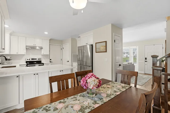 Kitchen featuring white shaker cabinetry, stainless steel appliances, solid surface countertops, and a subway tile backsplash