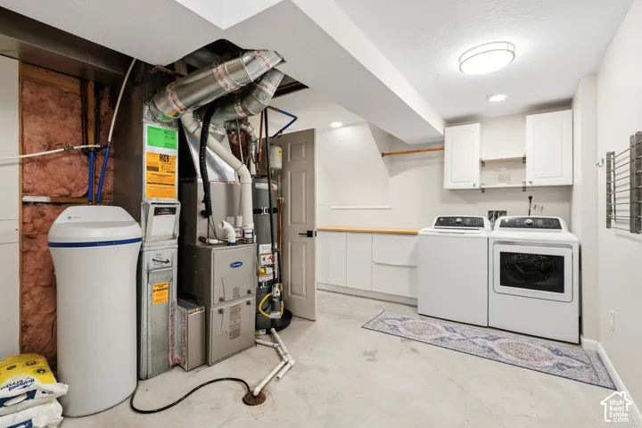 Dedicated laundry area featuring white cabinetry, a wood-finish countertop, and a built-in drying rack