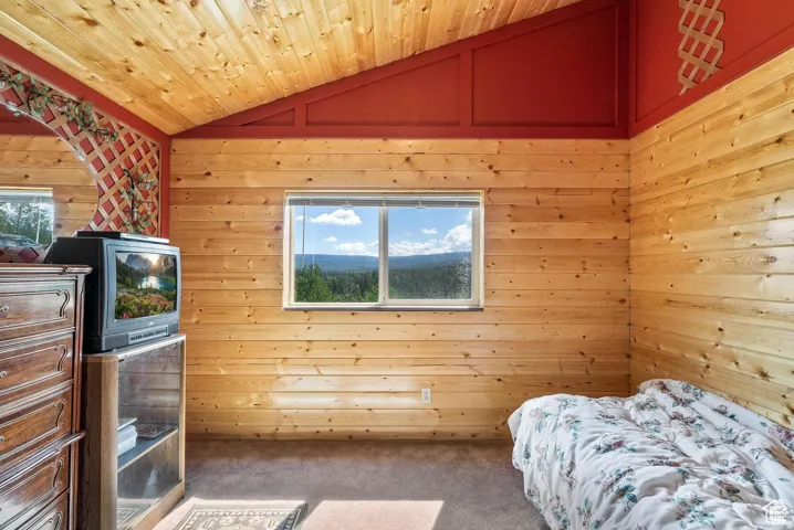Sloped wood-finish plank ceiling with exposed beams