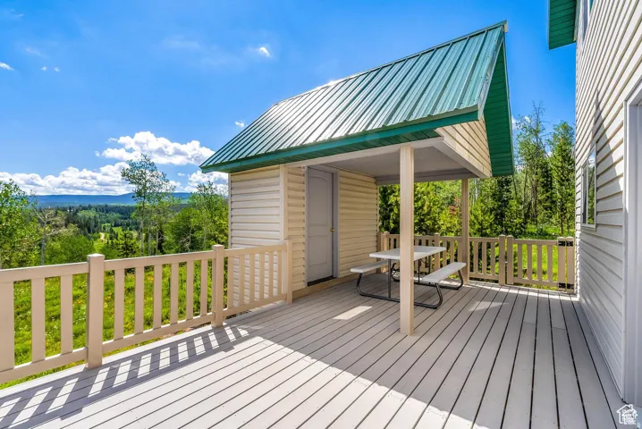 Expansive outdoor deck with composite decking, light-colored railing, and a covered patio area