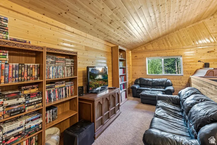 Wood-paneled room featuring a vaulted ceiling and horizontal wood-panel walls