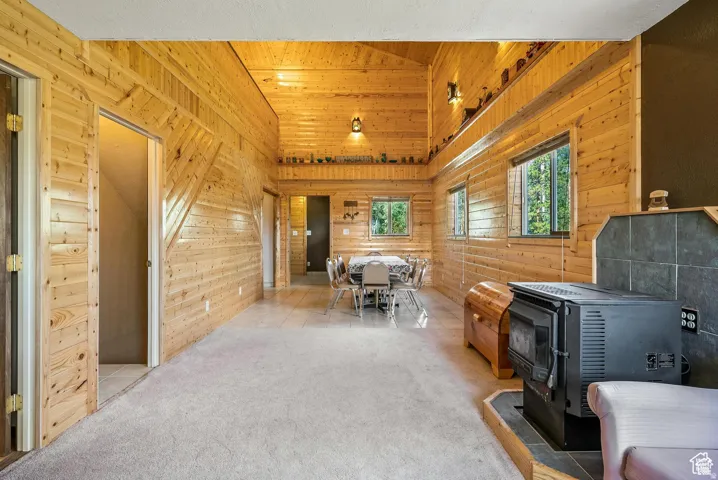 Interior space featuring wood-paneled walls and ceiling, a vaulted ceiling, recessed shelving, and multiple windows
