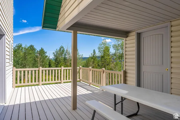 Expansive outdoor deck featuring wood-finish flooring and a wood-finish railing