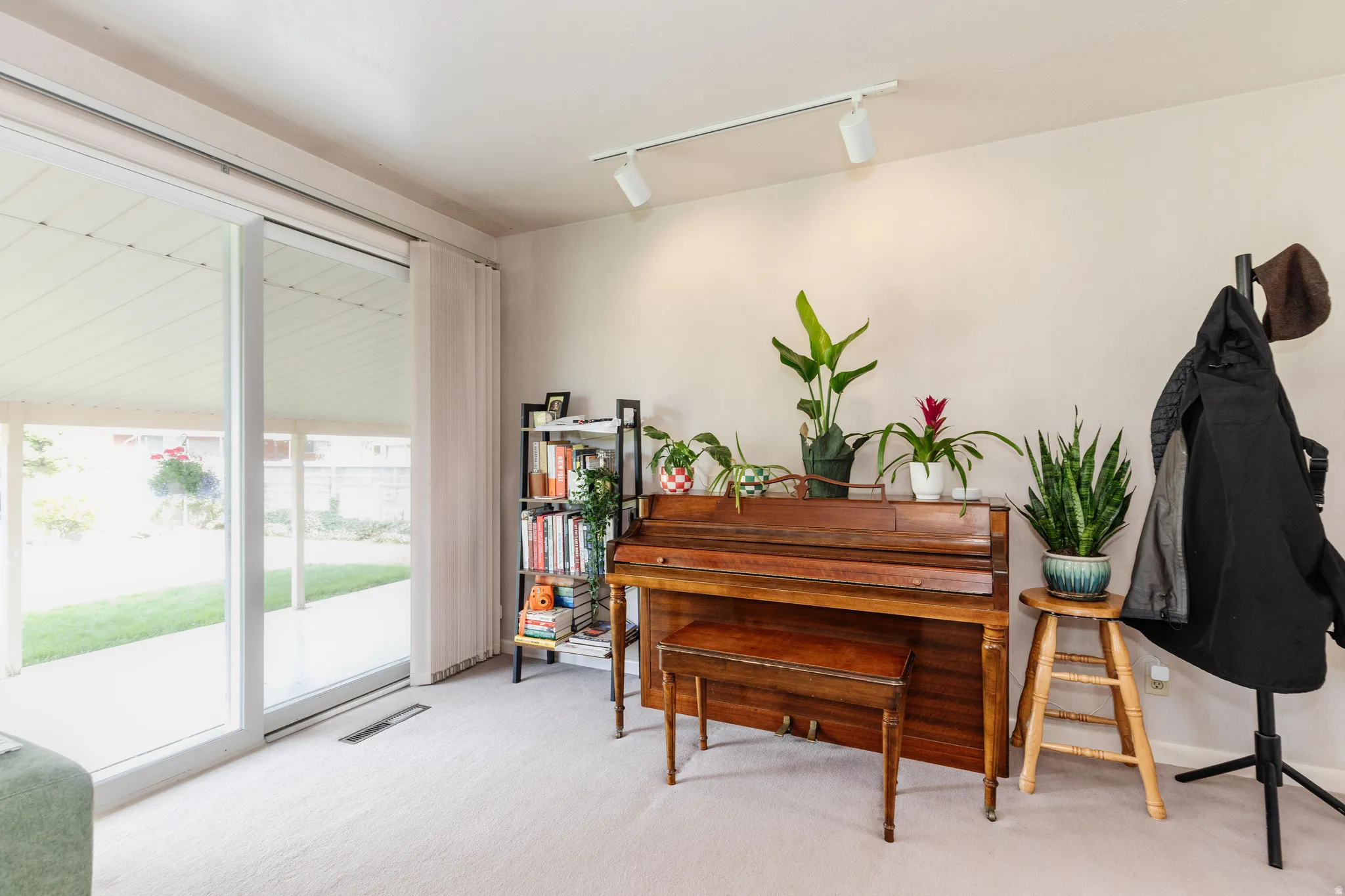 Sliding glass door opening to an outdoor patio and green lawn