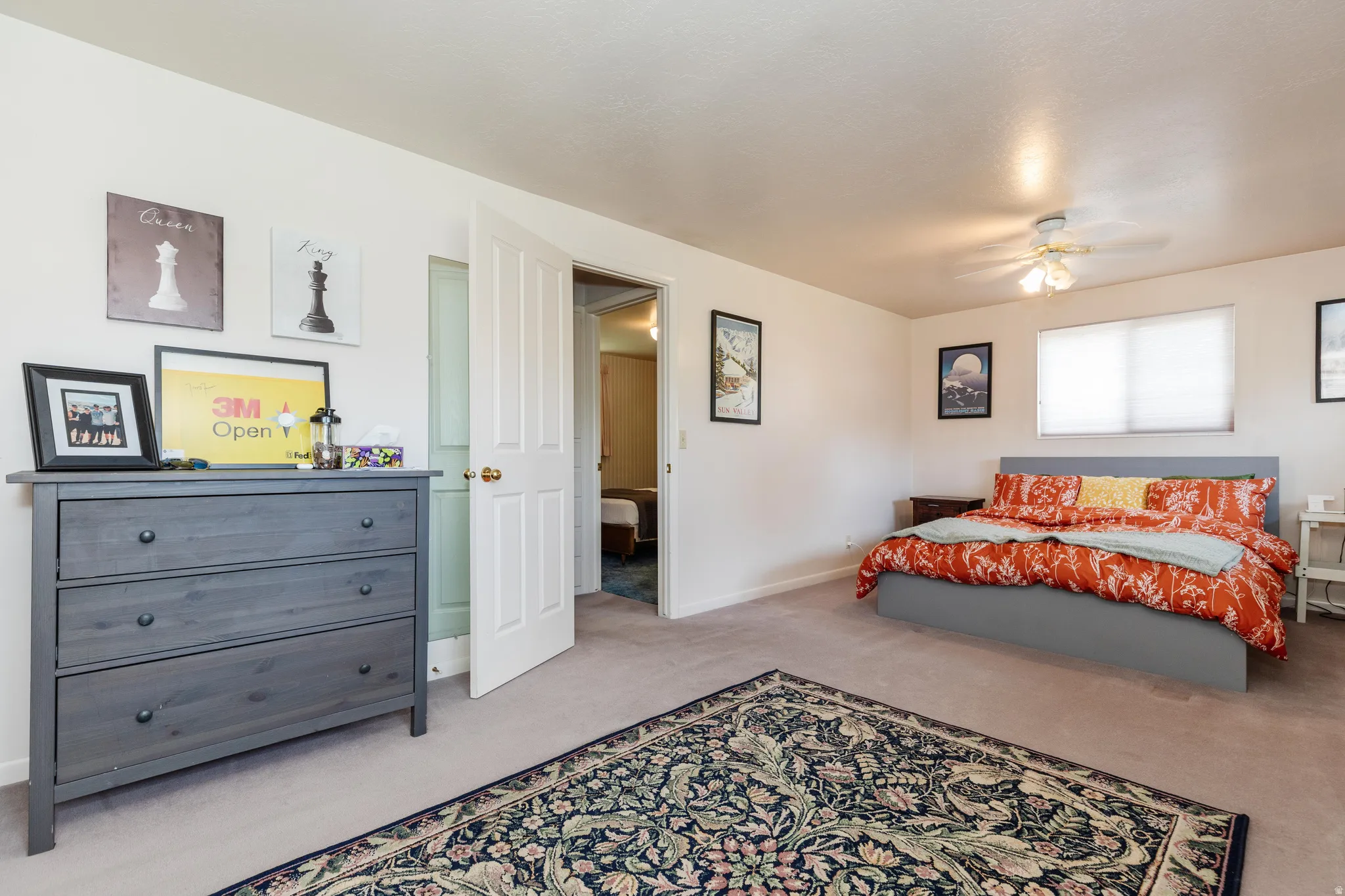 Spacious room featuring neutral carpeting, a ceiling fan with integrated lighting, and a double window with blinds